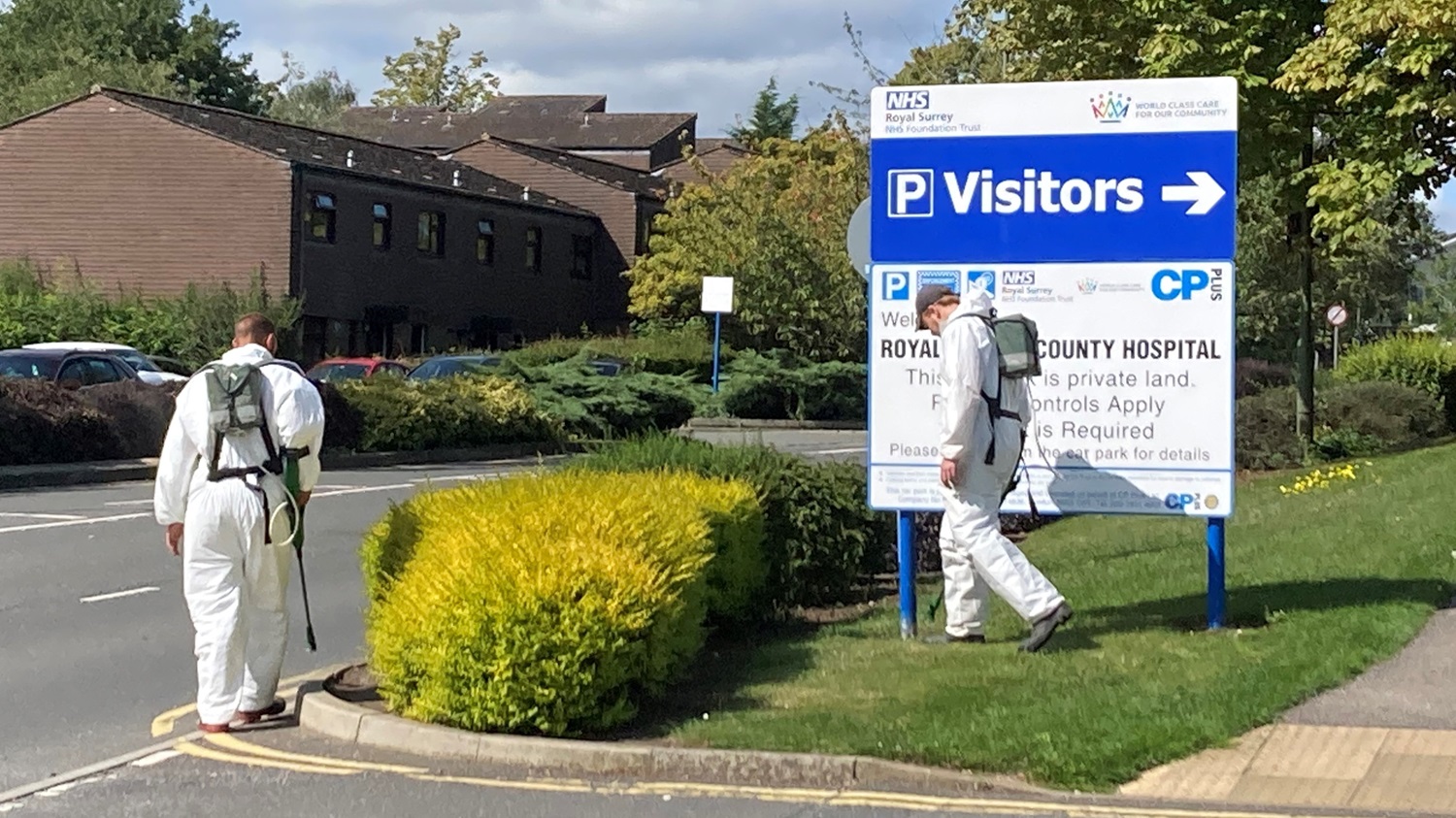 Workers spraying pesticides around the grounds of Guildford Hospital - Credit Fiona Scimone