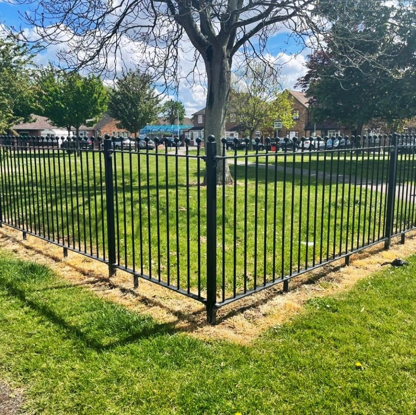 Example of spraying weedkiller around a park fence